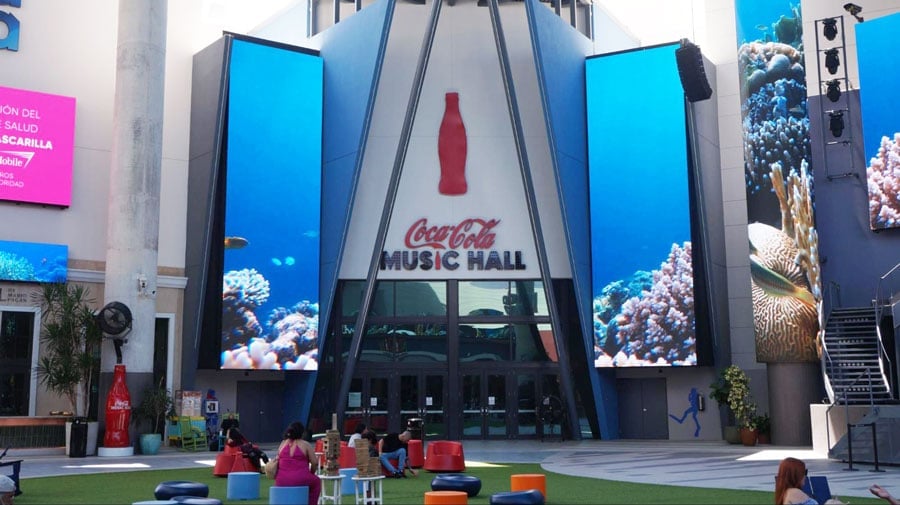 Vista de la entrada del Coca Cola Music Hall y gente sentada afuera