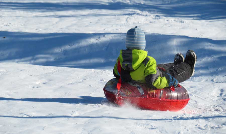 Vista de un niño divirtiéndose en un tubo de nieve