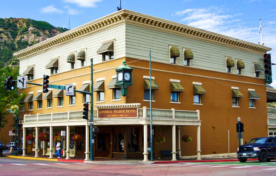 Vista exterior del vibrante edificio amarillo y blanco del General Palmer Hotel en Durango, Colorado