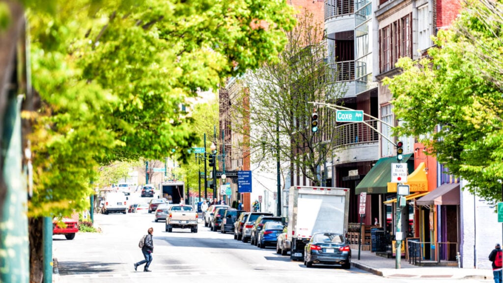 Un hombre que cruza la calle no tan concurrida de Asheville en un día soleado