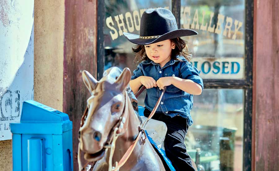 Un niño montando un caballo mecánico de juguete en Trail Dust Town